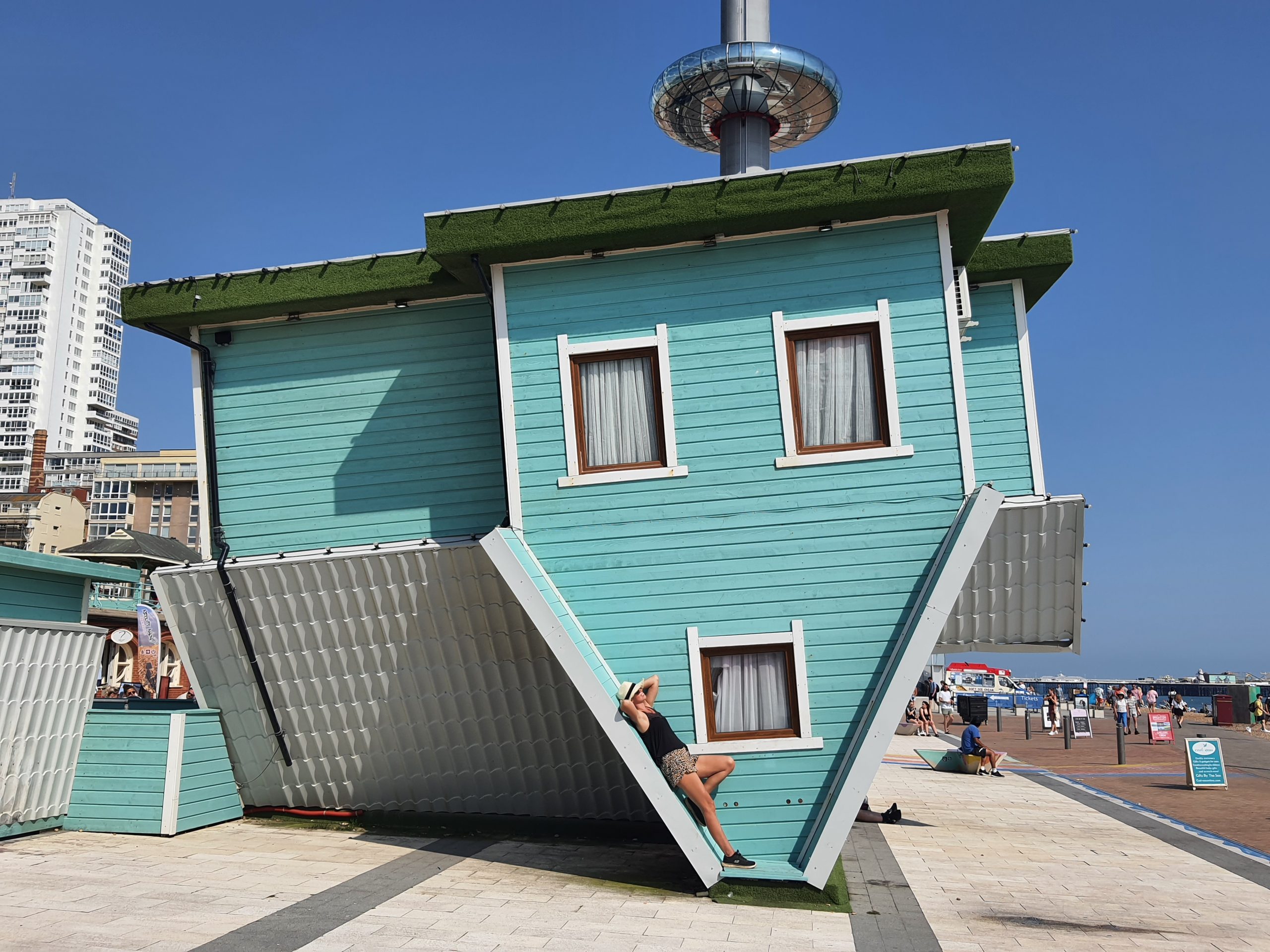 Upside Down House with the i360 observation tower in the background during a sunny weekend in Brighton