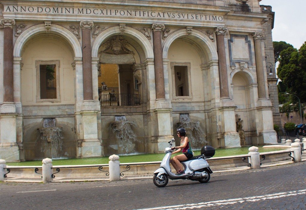 Whizzing past historic fountains on a vespa tour around Rome!