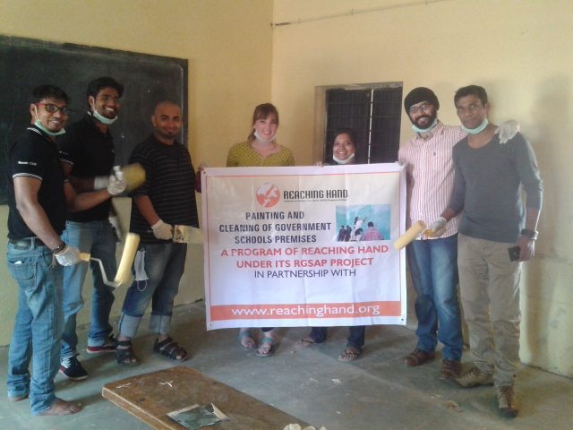 With volunteers, Reaching Hand