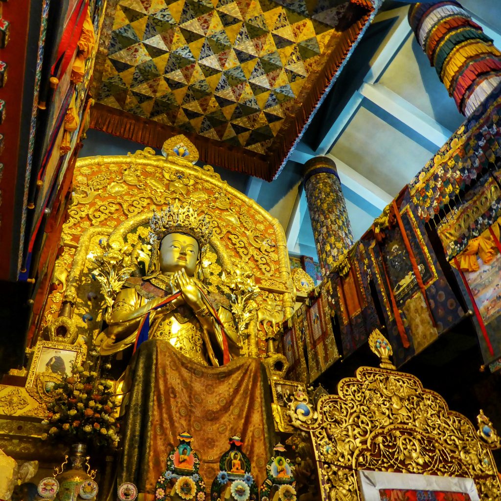 The massive, golden Buddha statue inside the Palpung Sherabling Monastery
