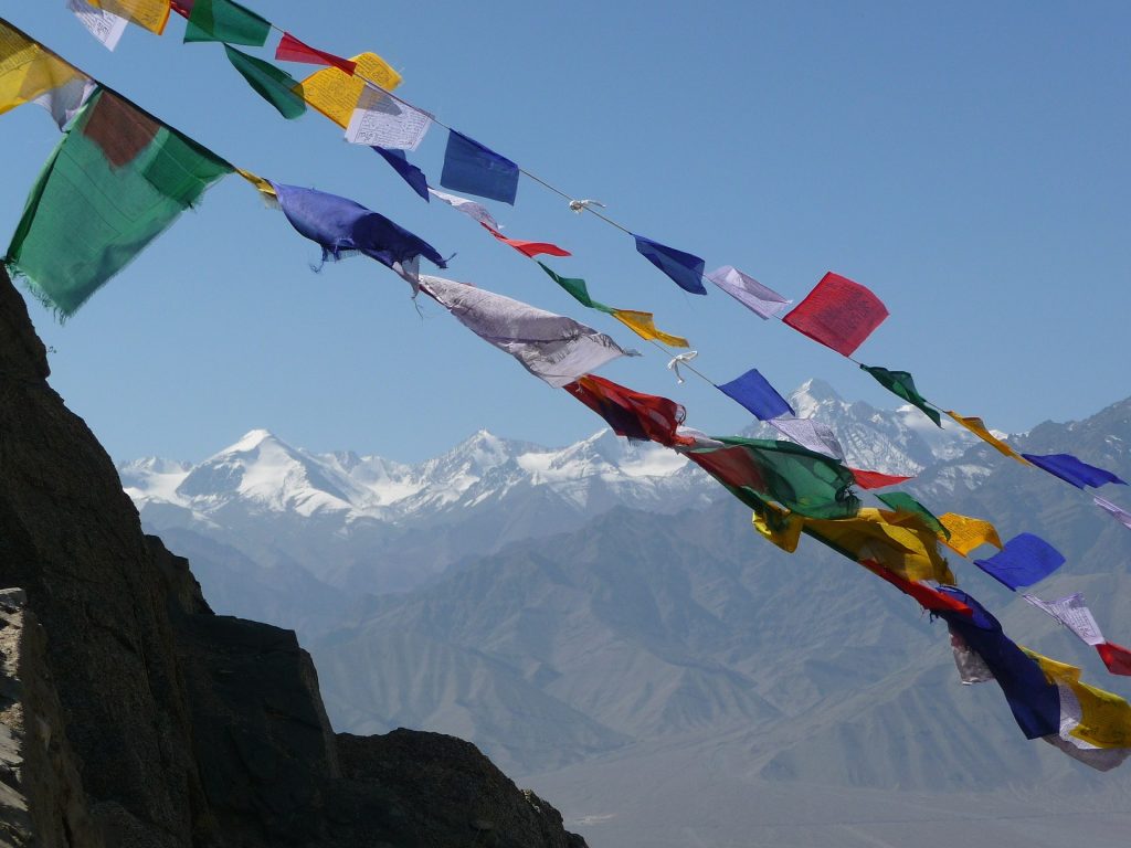 Colourful prayer flag and the snow capped Himalayas