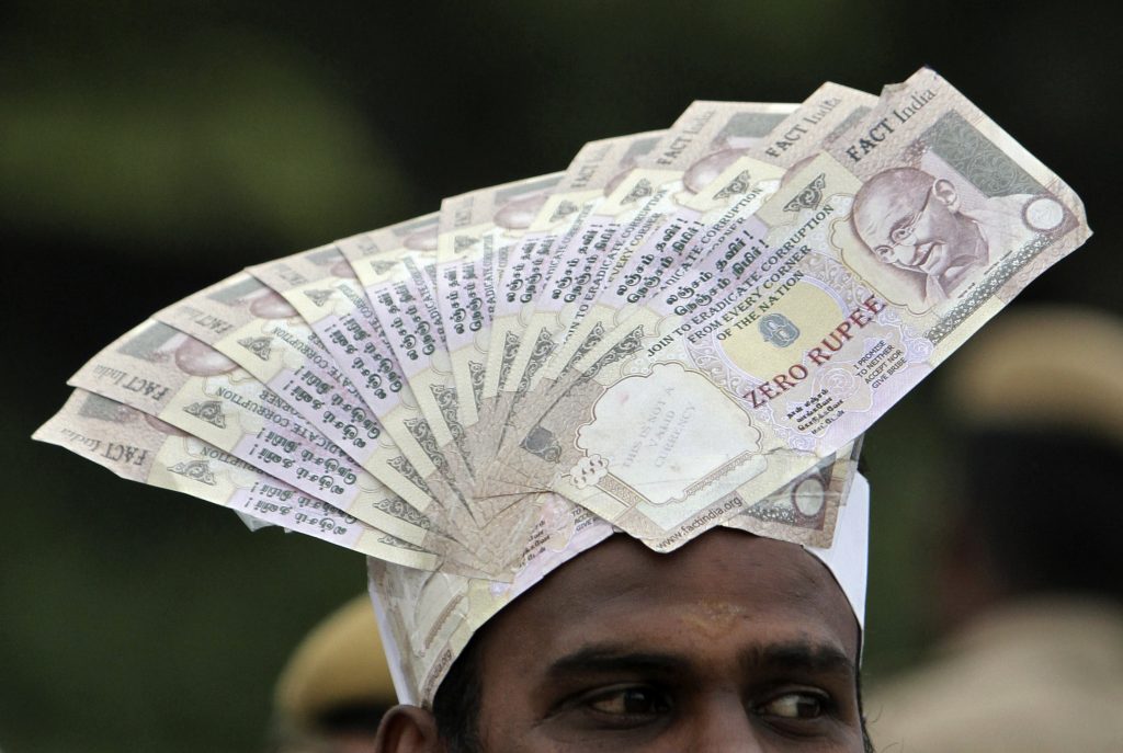 A supporter of veteran Indian social activist Anna Hazare wears a cap lined with fake currency notes while attending a public meeting by Hazare in the southern Indian city of Chennai December 18, 2011. Hazare, while addressing a public meeting on Sunday, said he was firm on his plan for an indefinite fast later this month if the government did not bring an effective anti-graft legislation in Parliament. REUTERS/Babu 