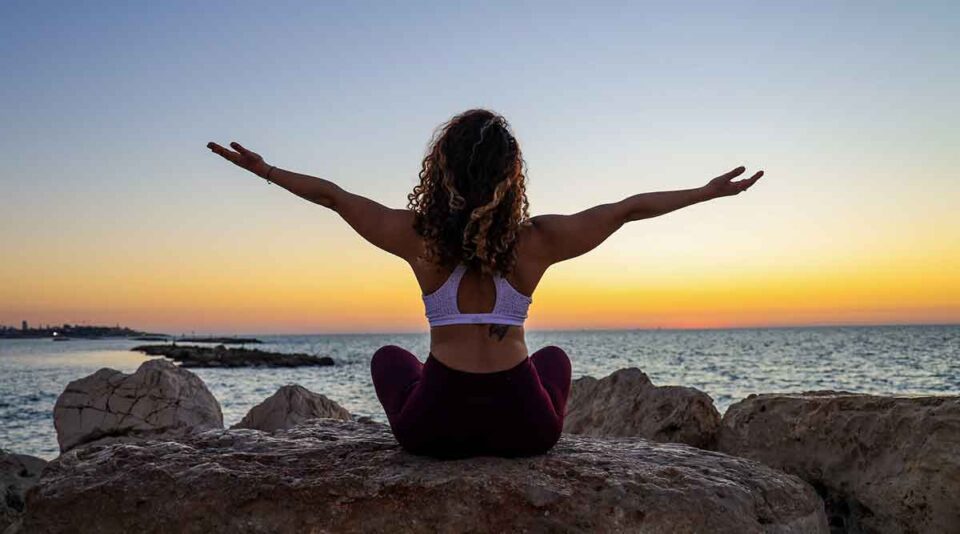 yoga retreat on the rocks at sunset at one of the best yoga retreats in the world