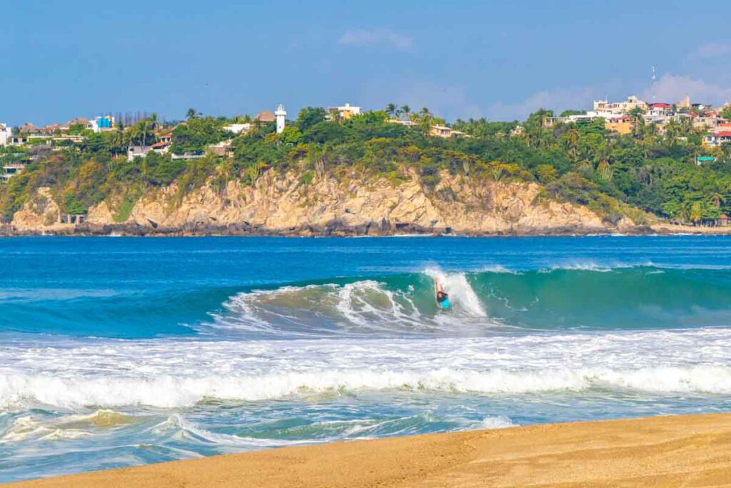 Surfer surfing on surfboard on high waves in Puerto Escondido Mexico