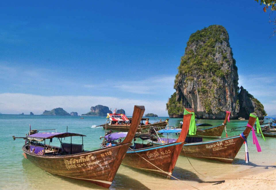 Longtail boats on a beach in Thailand 2 week itinerary