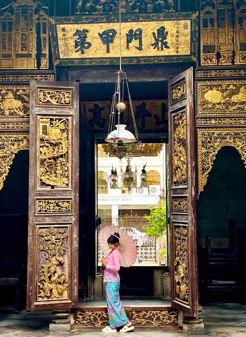 peranakan girl in traditional dress at the peranakan house in penang malaysia